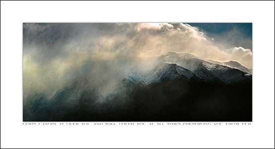 Heavy low cloud cover hanging over snowy mountain range.
